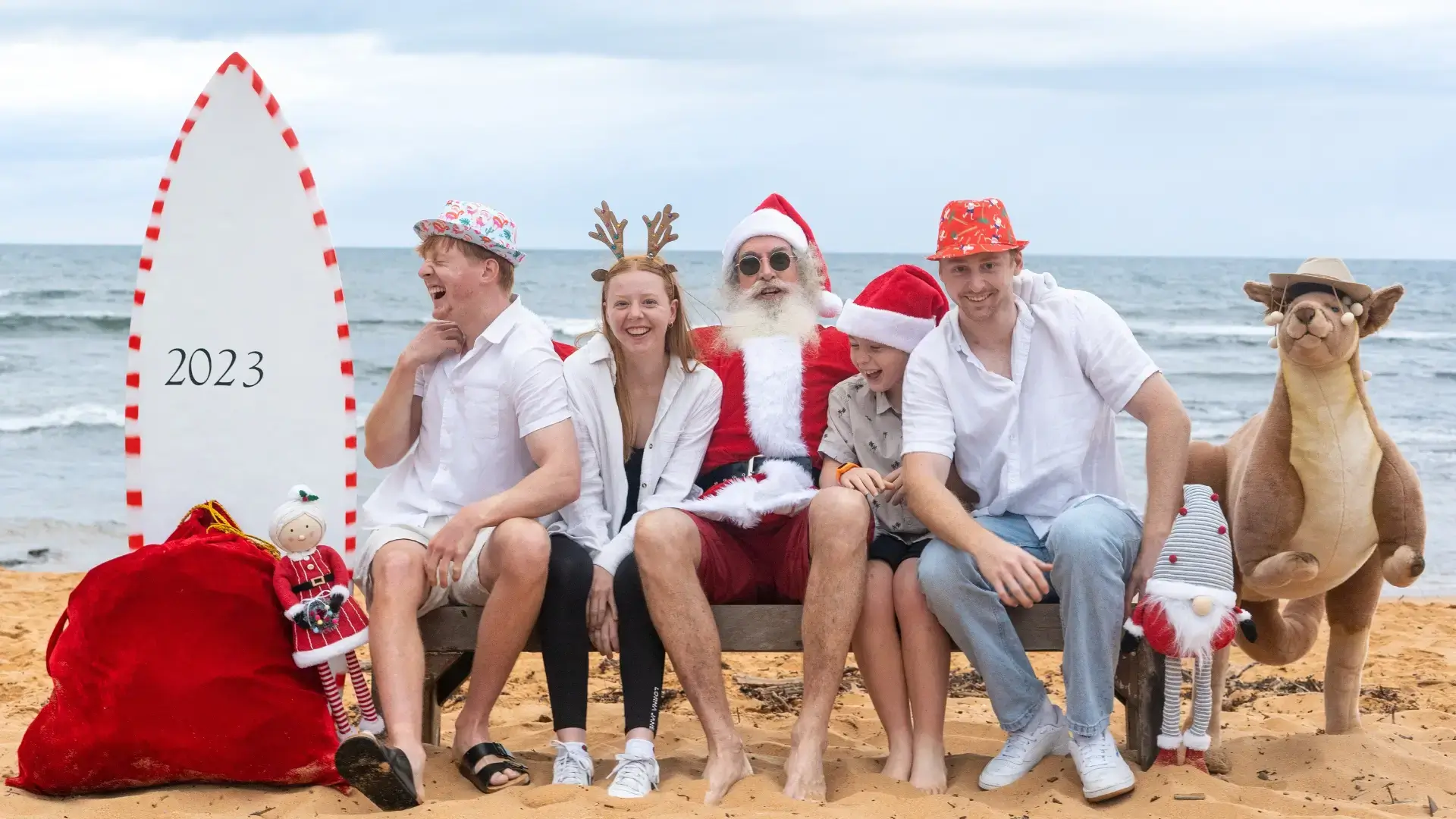 Family of 4 having a fun photo shoot with Santa on the Beach